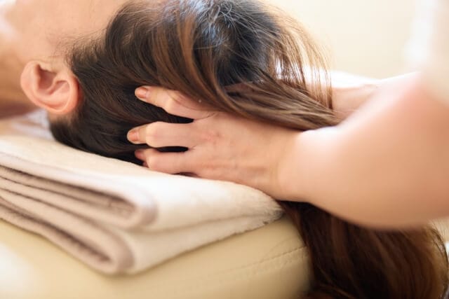 ドライヘッドスパの施術を受けている女性。